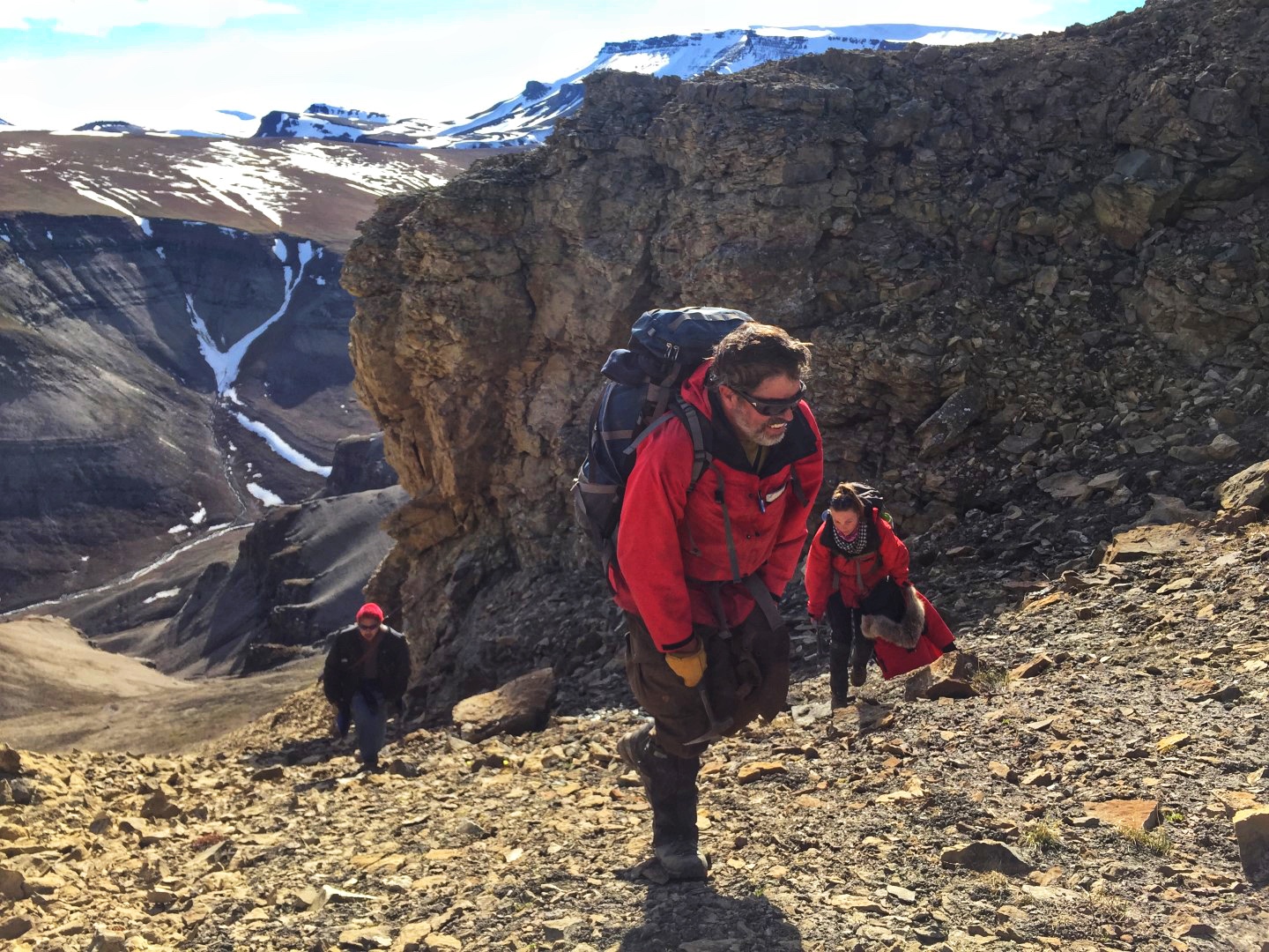 Steve Grasby and team carrying heavy bags of rocks collected from outcrops on northern Ellesmere Island. 
